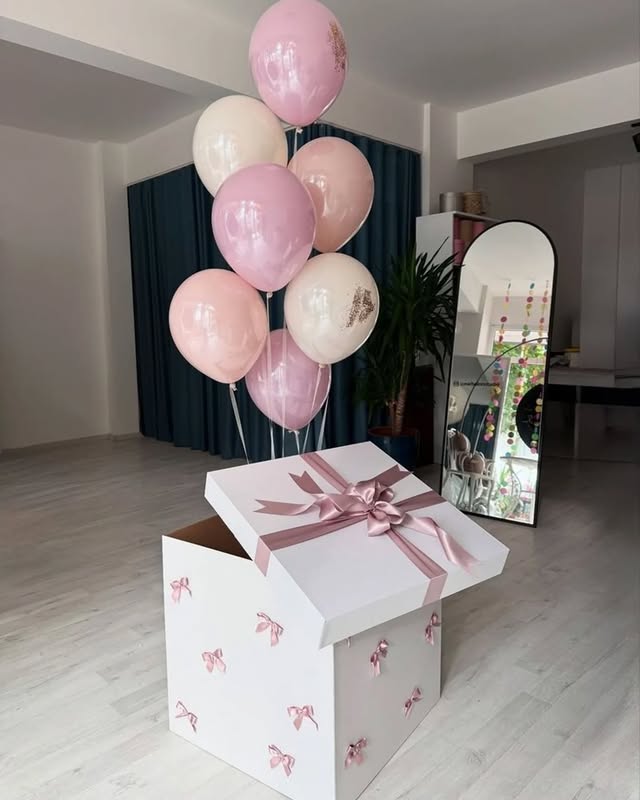 Pink surprise box with bow and pastel balloon bouquet